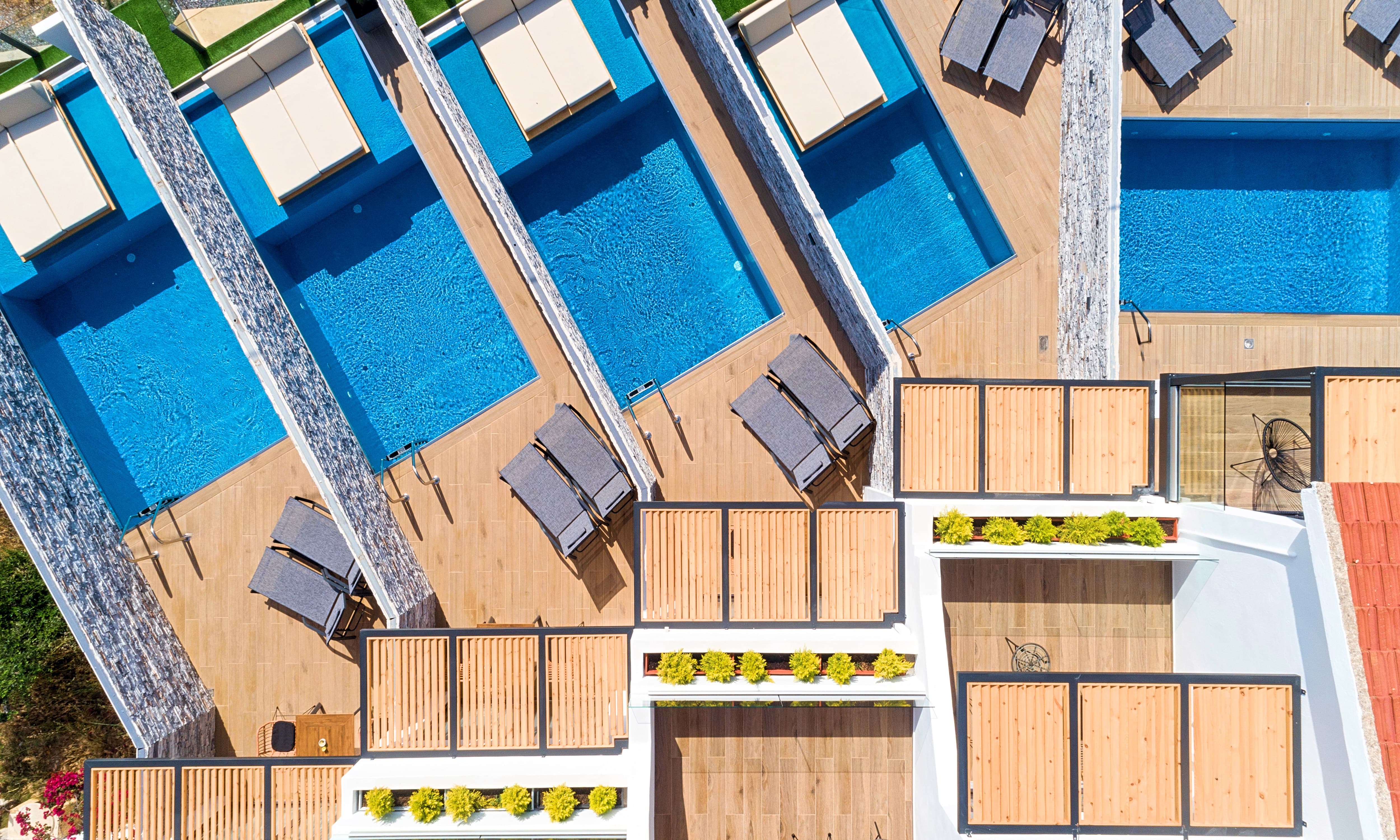 Buitenzwembad met ligbedden — Aelia Suites