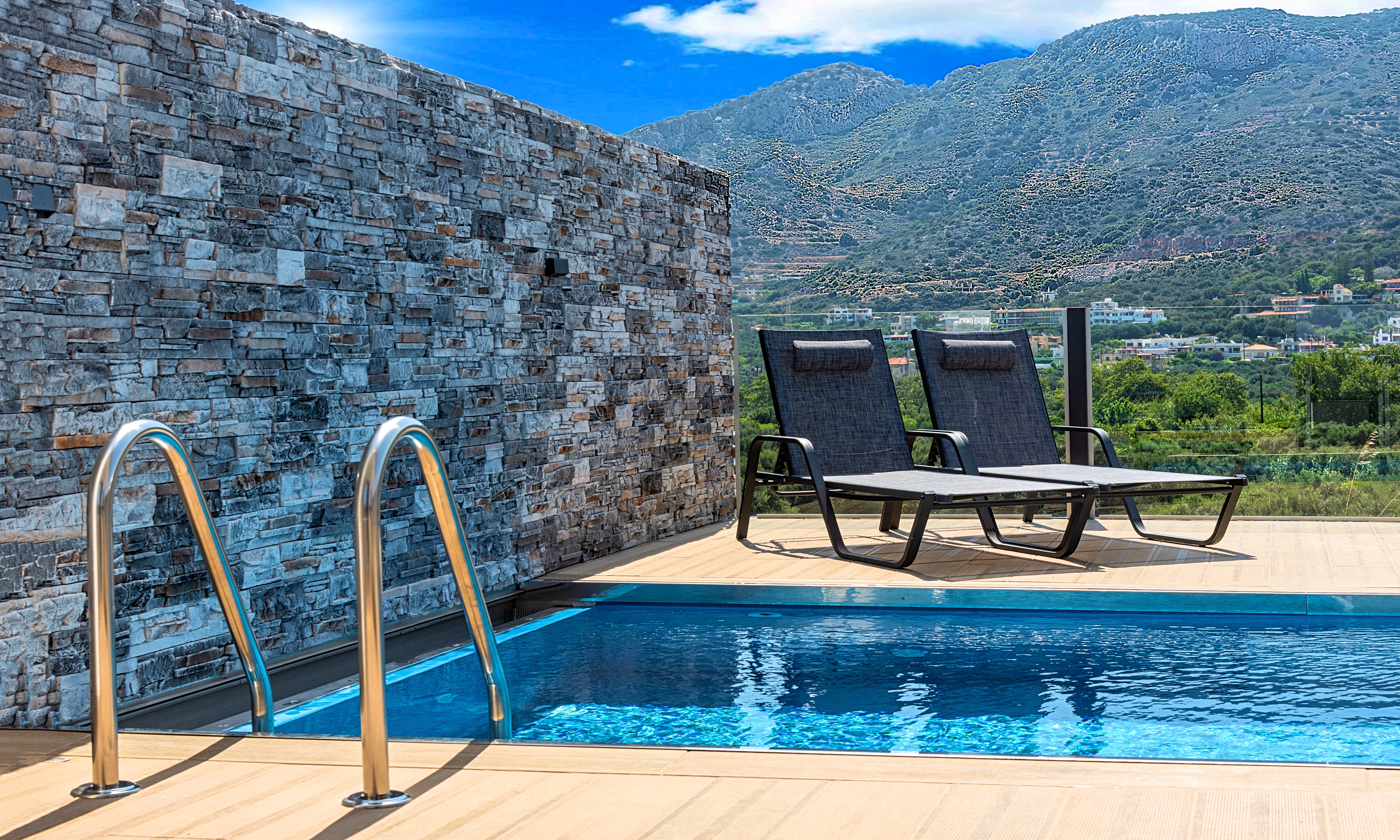 Buitenzwembad met ligbedden — Aelia Suites