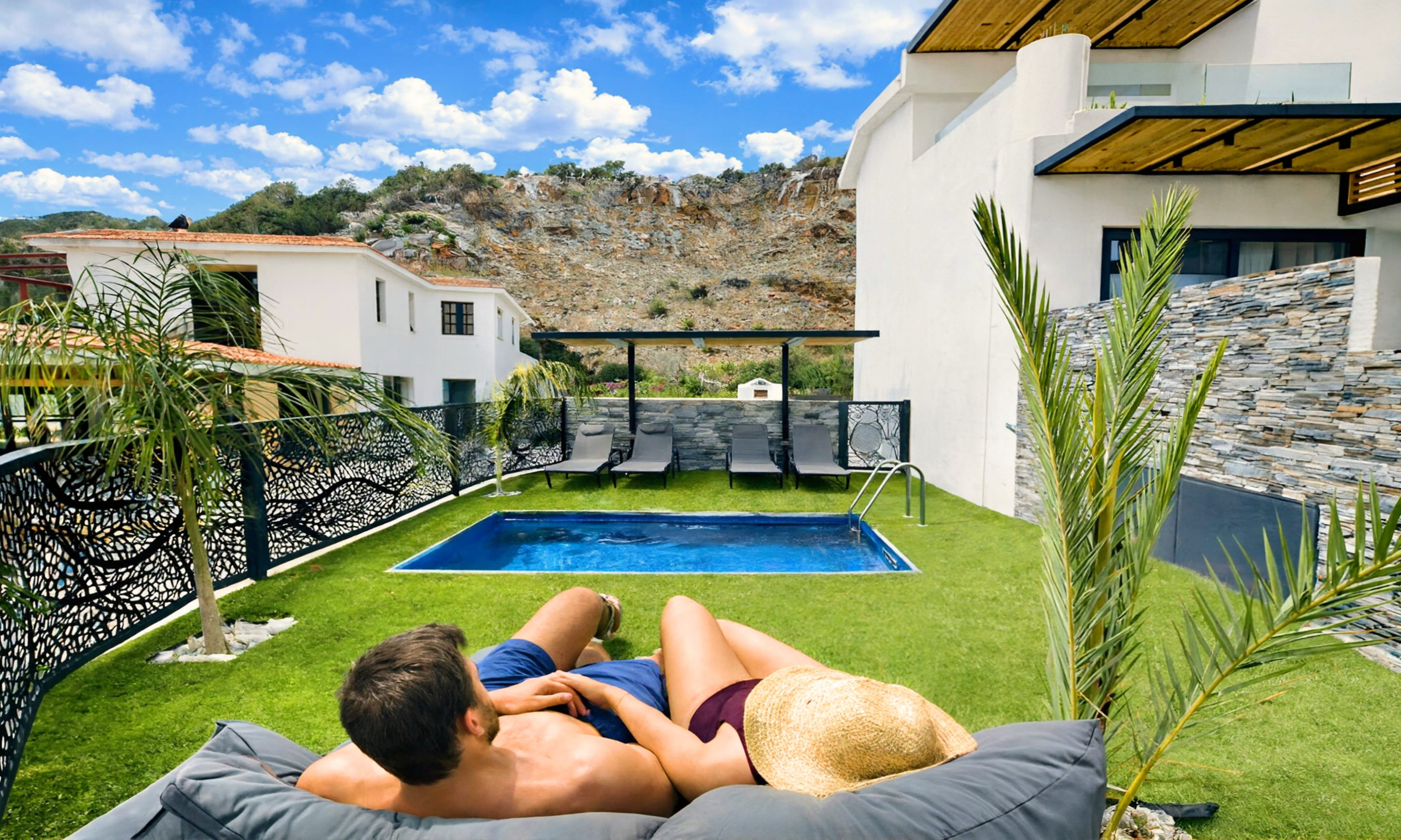 Buitenzwembad met ligbedden — Aelia Suites