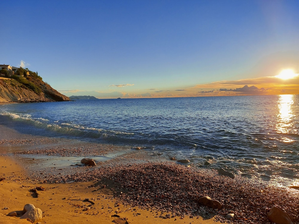 Strand bij zonsondergang — cala lanuza suites