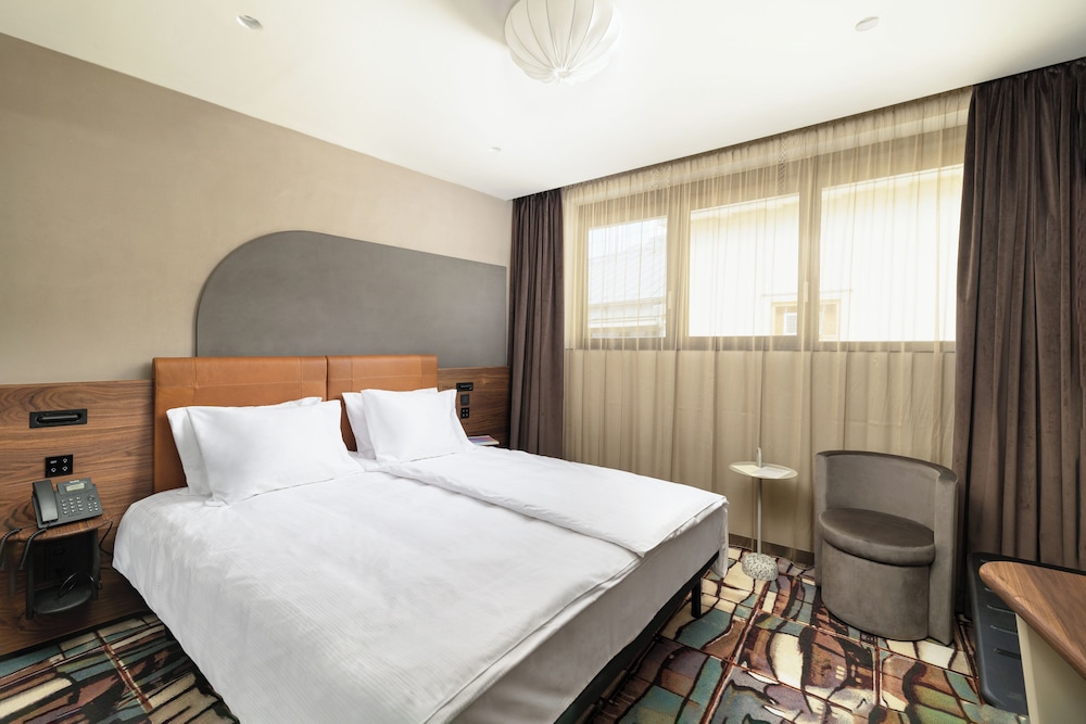 Ruim hotelkamer met comfortabel bed bij Hotel Gin Budapest