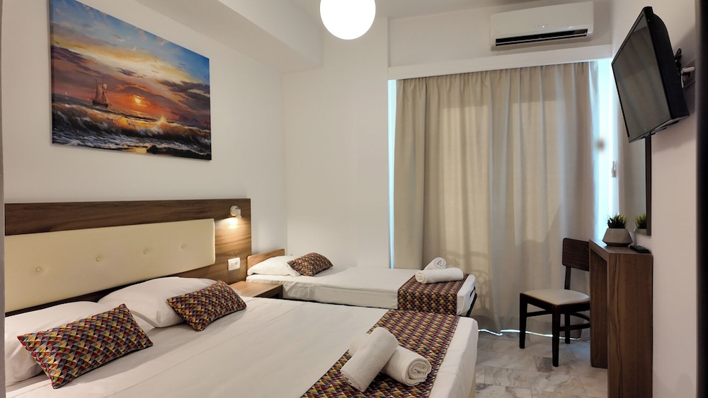 Slaapkamer met witte muren en comfort inrichting in Hotel Santorini