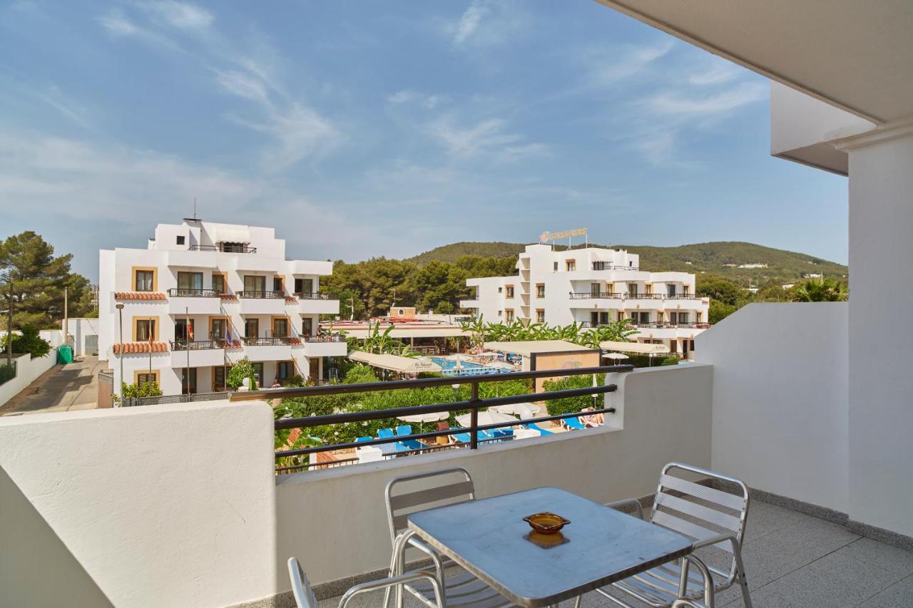een balkon met een tafel en stoelen en gebouwen bij Invisa Aparthotel Casa Luis in Santa Eularia des Riu