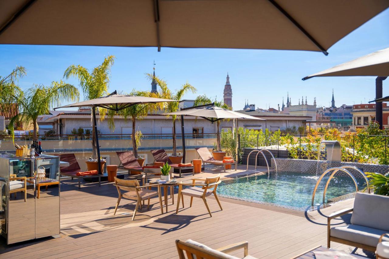 een terras met tafels en stoelen en een zwembad bij Ocean Drive Madrid in Madrid