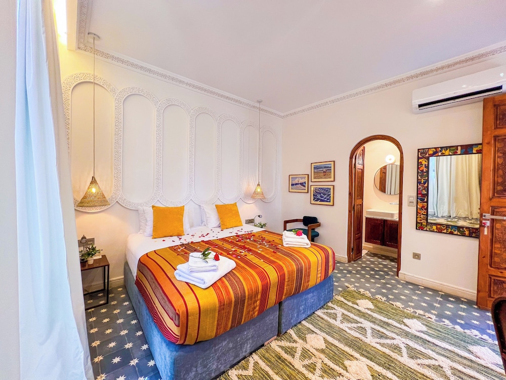 Slaapkamer Riad Kech One & Spa met Marokkaanse tegels en zijden beddengoed