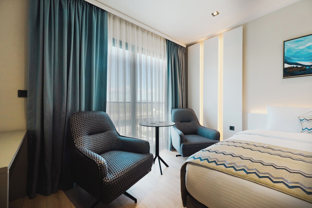 Slaapkamer met hoogwaardig bedlinnen bij Stillo Business Hotel & SPA